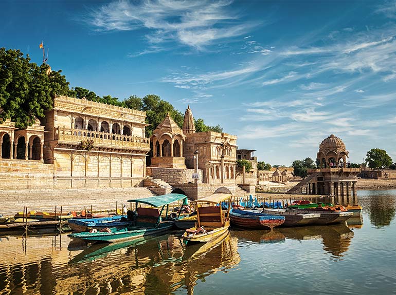 Small wooden boats docked in front of a temple in Jaisalmer, India.