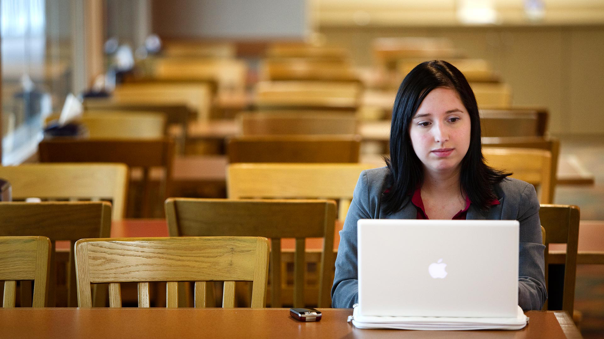 An Opus College of Business graduate student works on her laptop