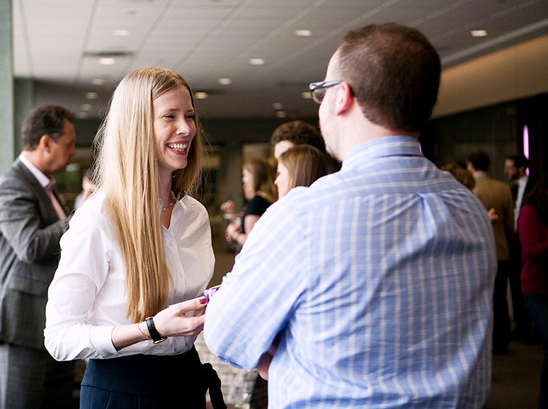 Graduating student shares a laugh with her faculty adviser at a reception.