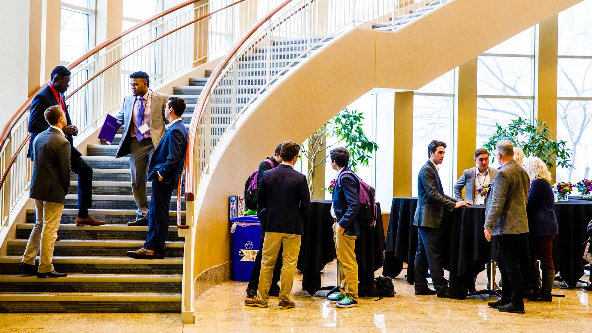 Guests converse during an event held in the Schulze Hall atrium.