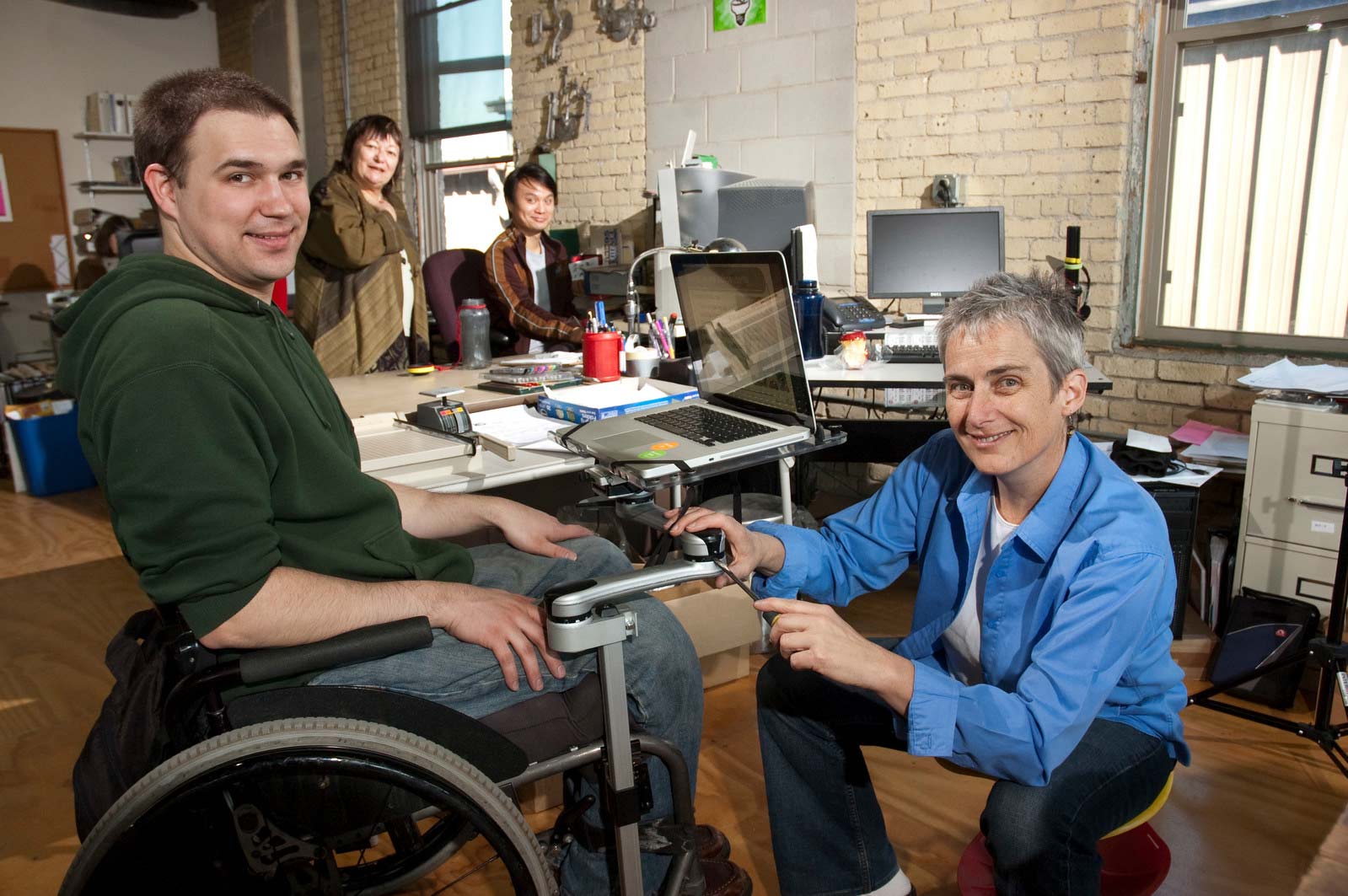 Blue Sky Designs founder Dianne Goodwin and Production Manager Peter Bohl showcase the Mount'n Mover, an attachment arm for wheelchairs that allows items to be connected "hands-free."
