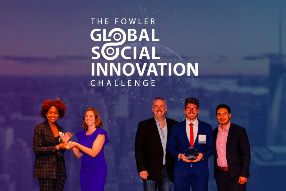 a group of people standing in front of a screen that reads Fowler Global Business Challenge