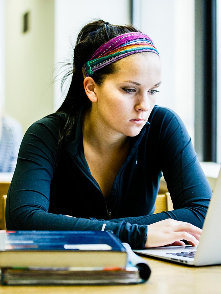 Student Vanessa Seiberlich studies on her laptop in O'Shaughnessy-Frey Library.