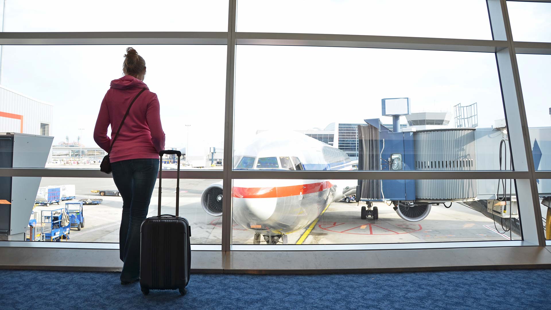 A person looking at an airplane set to unload passengers.