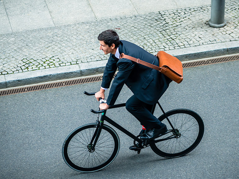 Business professional rides a bike. 