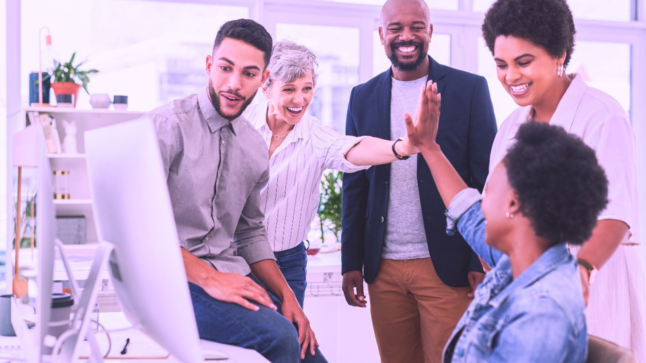 Professional with laptop sitting and reviewing papers.