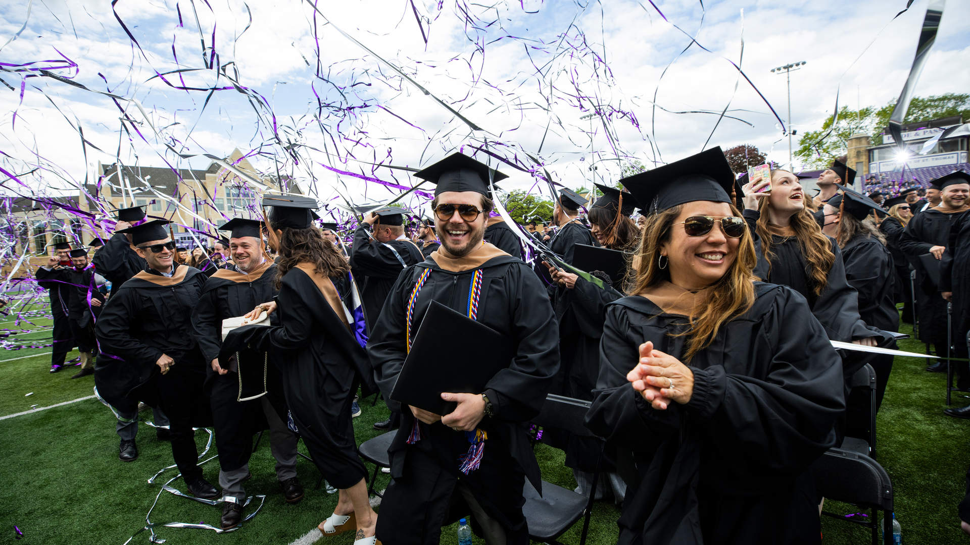 graduate students walking across a stage