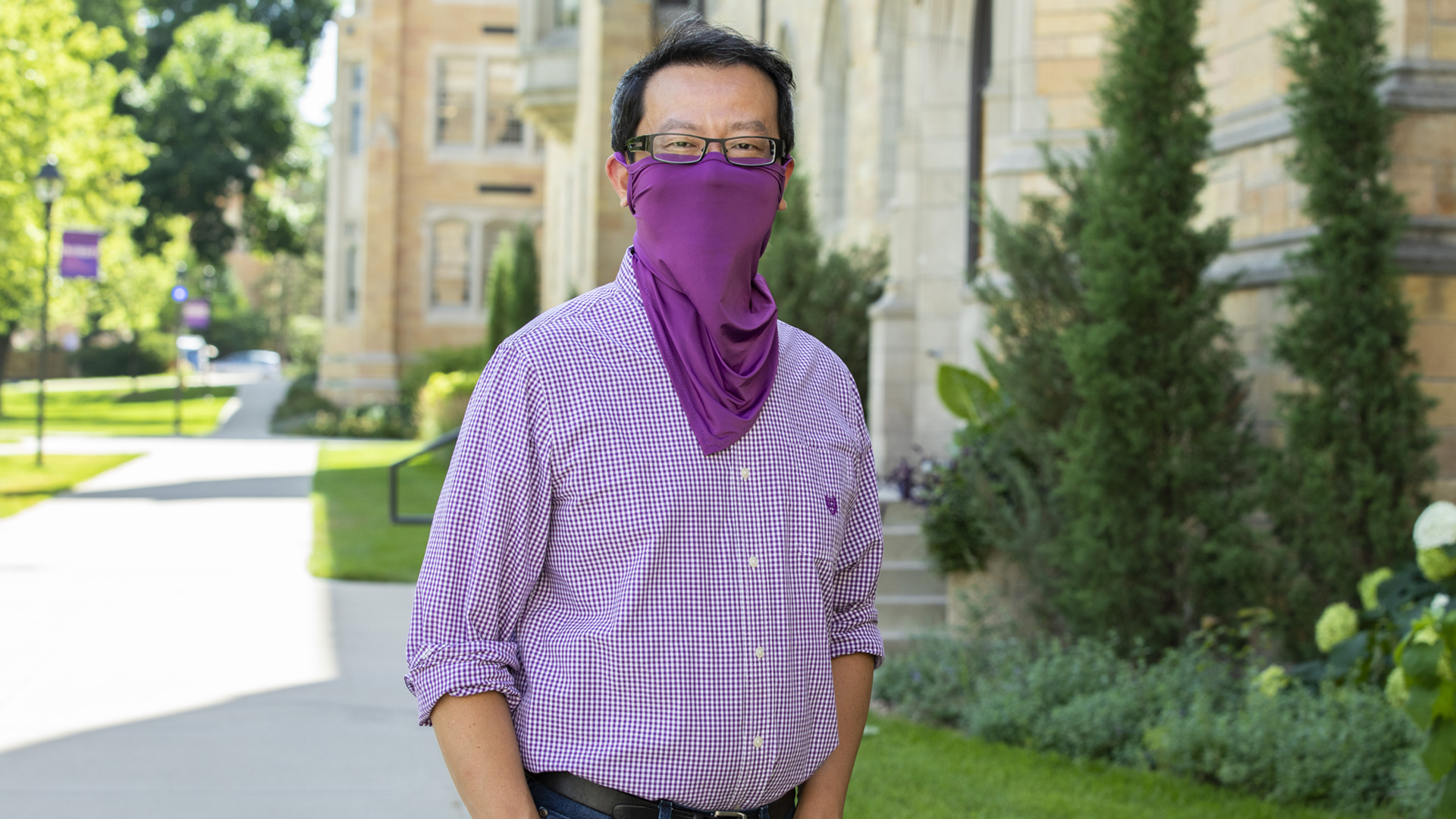 Professor of Accounting Lawrence Chui stands outside campus with a purple mask