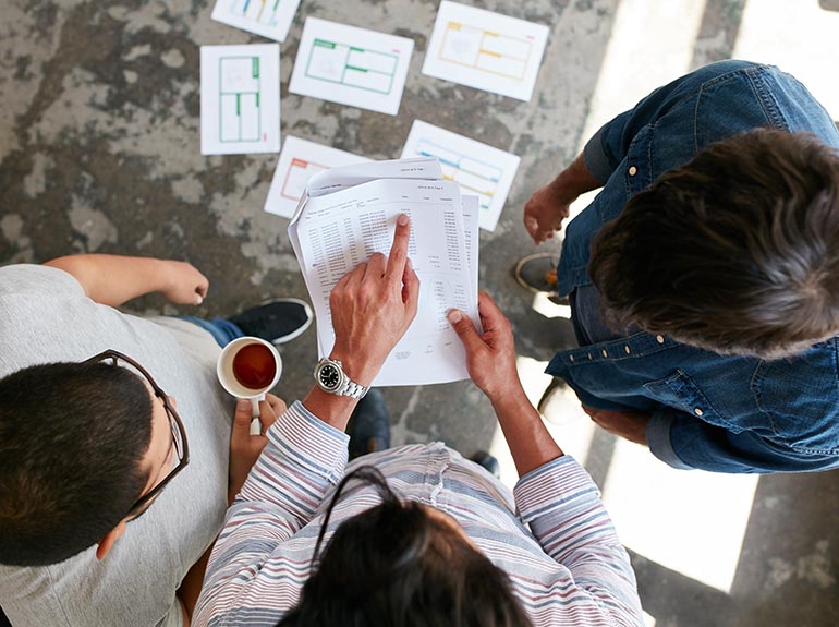 Three business men reviewing report.