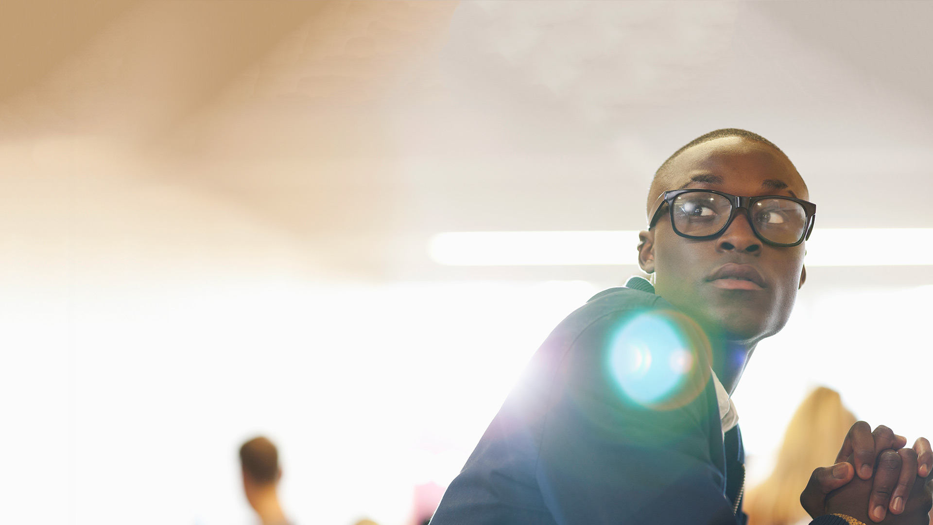 business student sitting and slightly looking back over his shoulder.