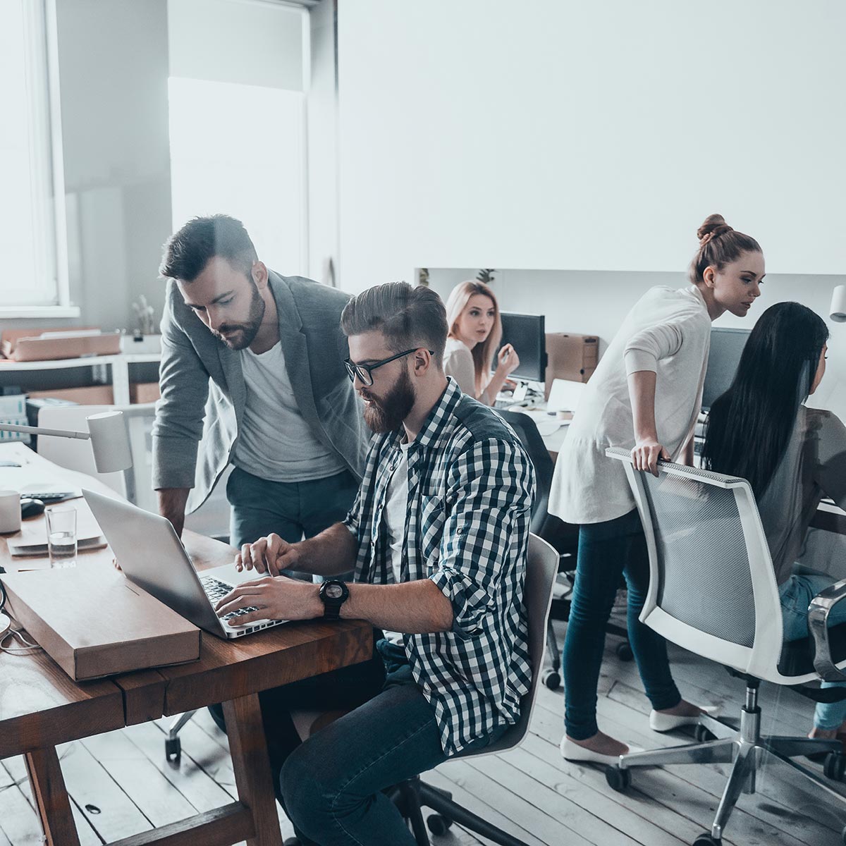 A group of business students in a computer lab helping one another.