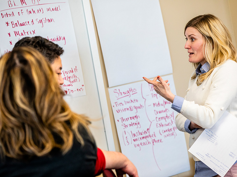 A female student participates in a group exercise during an Opus College of Business class.