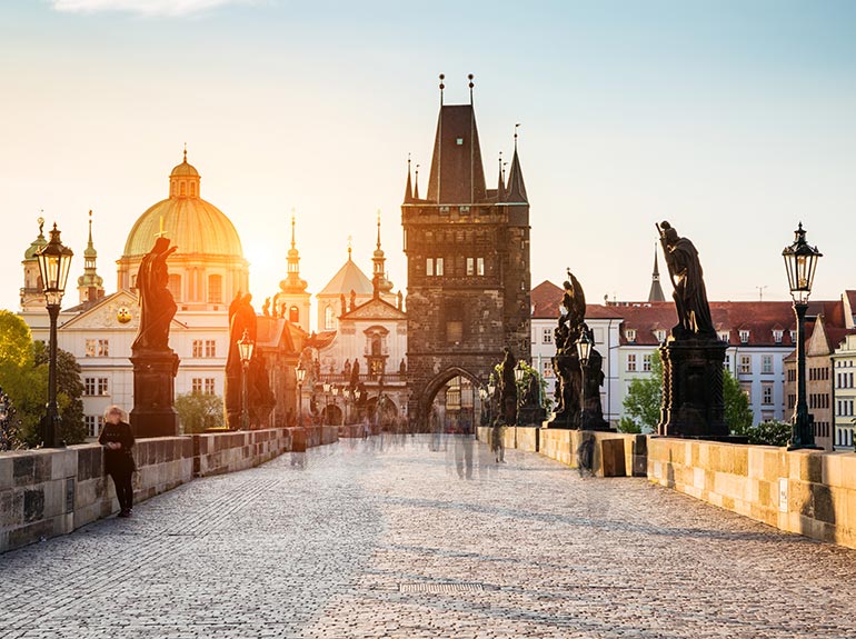 People walking in front of a series of beautiful buildings.