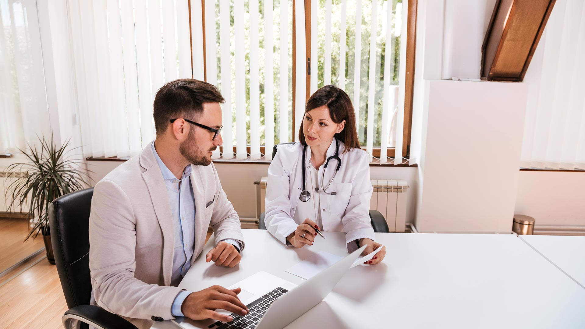 Doctor in discussion with a healthcare administrator in an office.