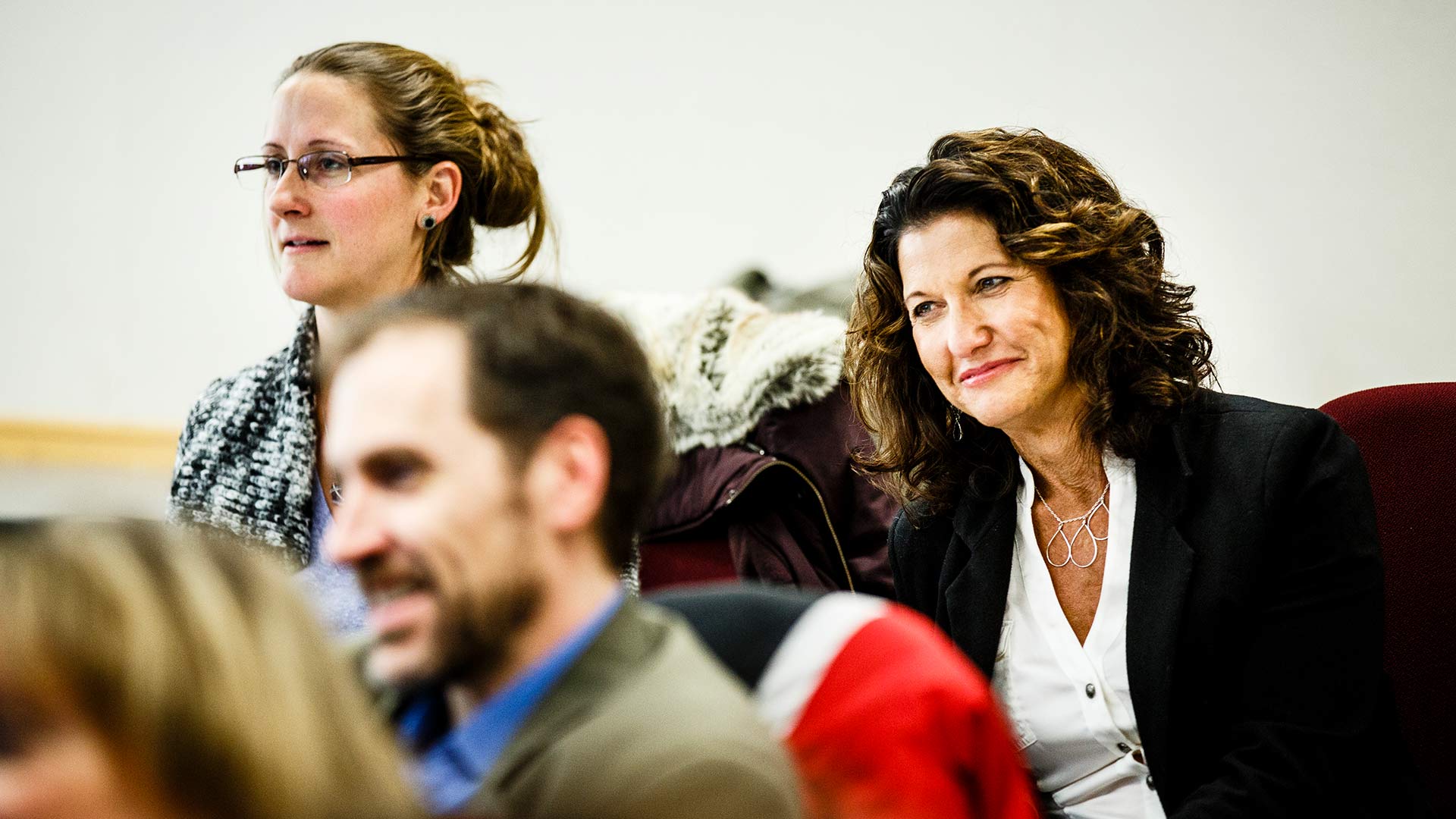 Two women smiling during a class in the Opus College of Business in Terrence Murphy Hall in Minneapolis