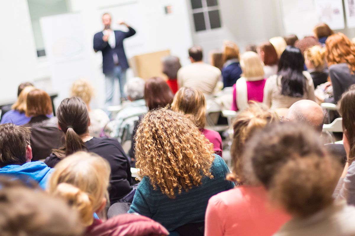 A group of attendees listening to a speaker in a seminar.