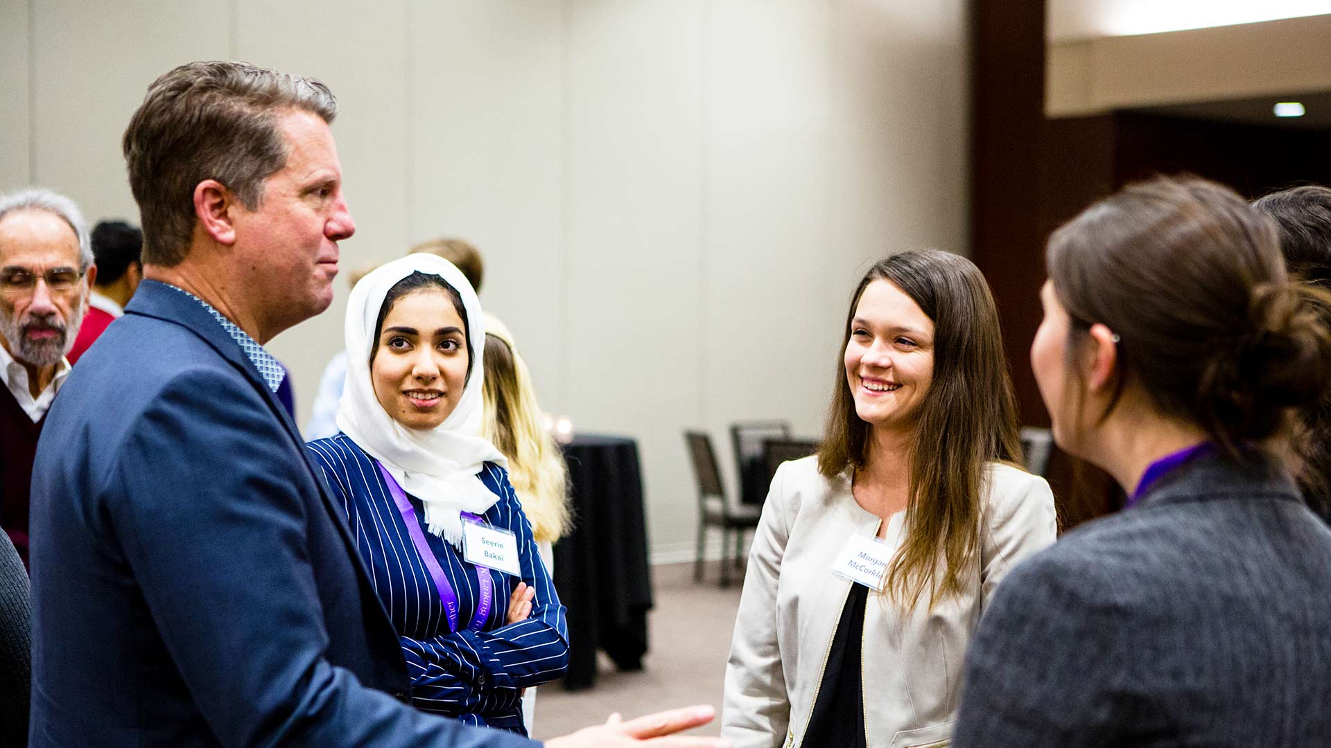 A group of individuals mingling and smiling at an event.