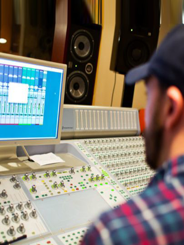 A professional in a music studio booth.