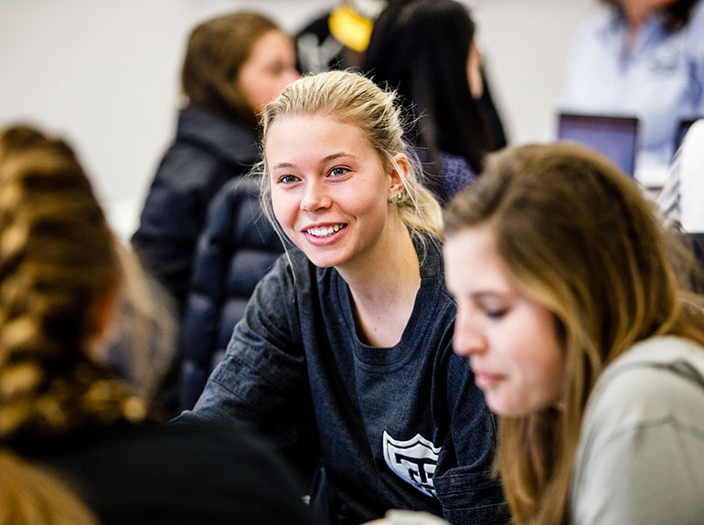 Students chat over a group project. 
