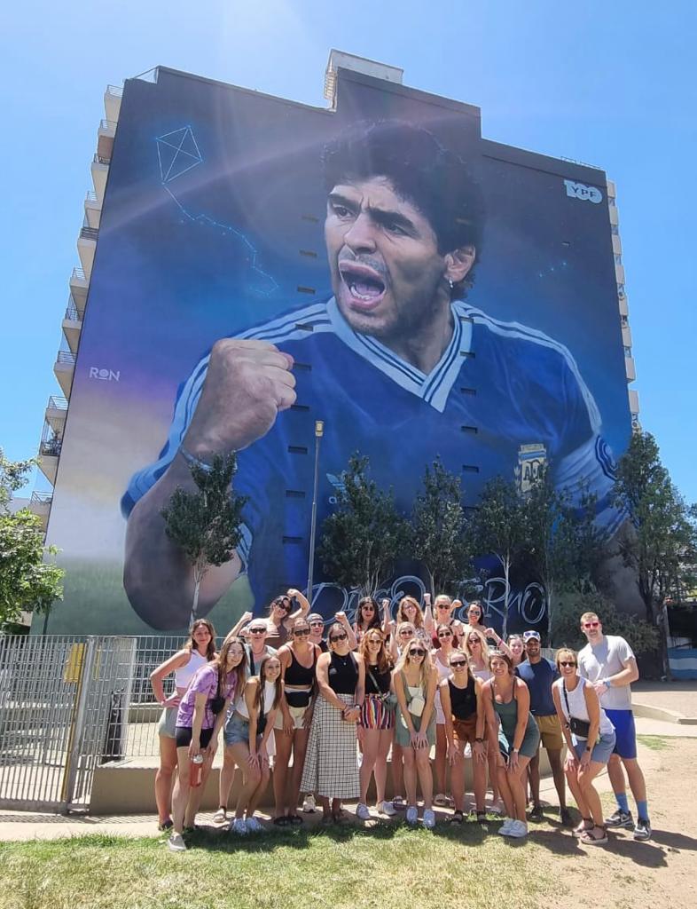 Students in Buenos Aries outside of a building with art on side