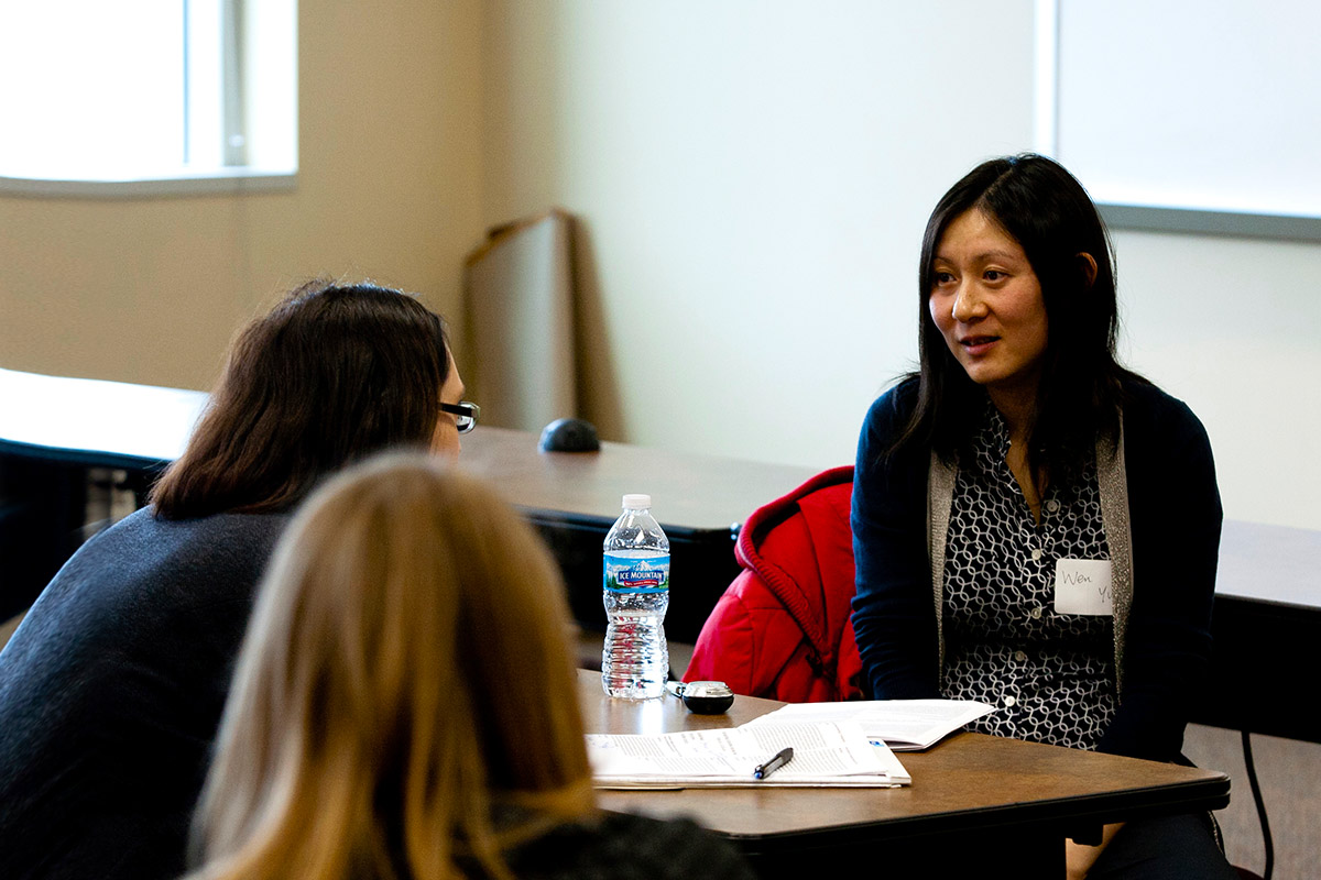 Faculty participate to share work with one another in a research meeting.