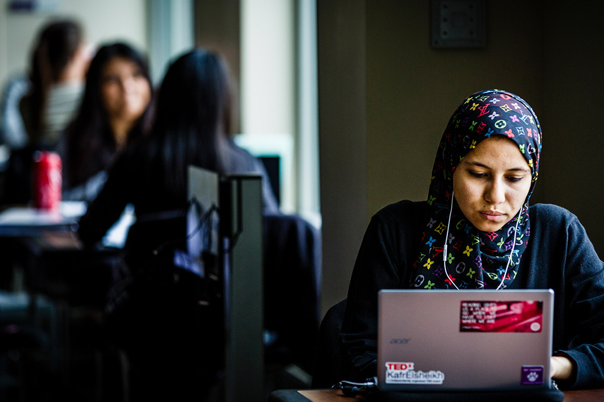 Student works with her laptop while listening to music.