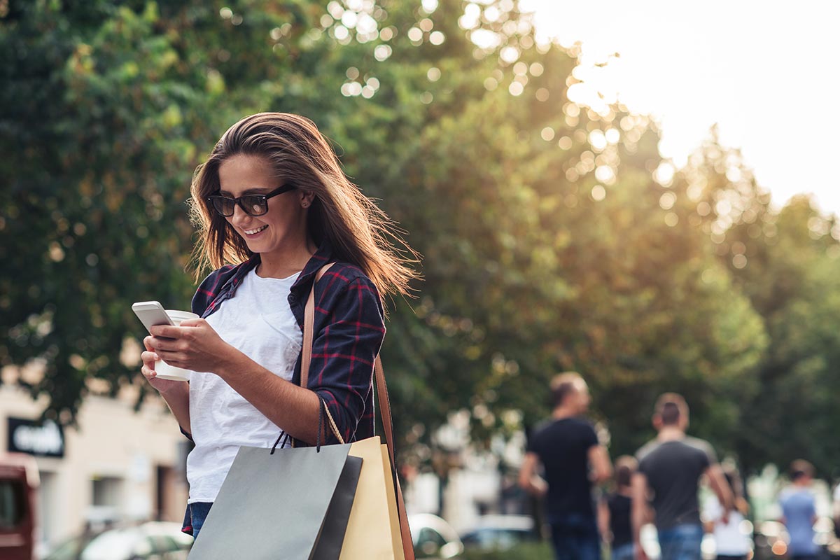 A woman smiling while looking at her phone