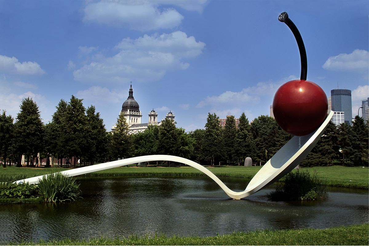 A large spoon with a cherry suspended on the rim at the walker art center