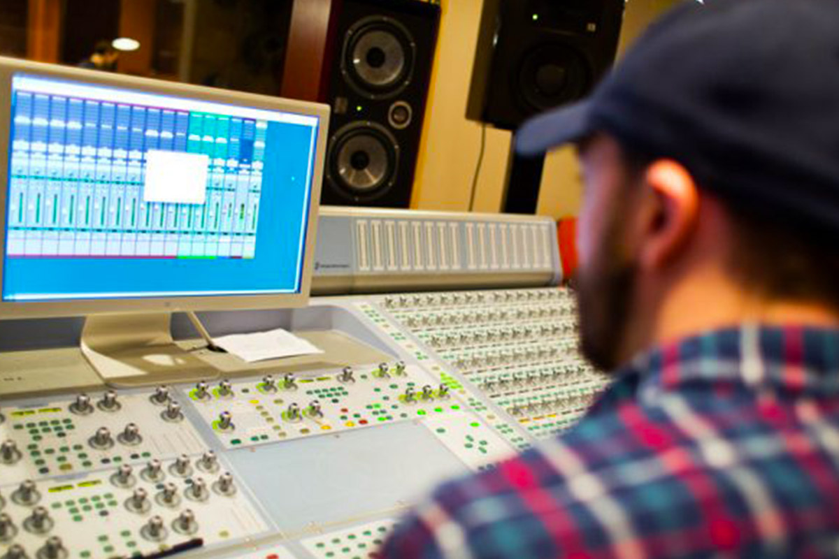 A professional in a music studio booth.