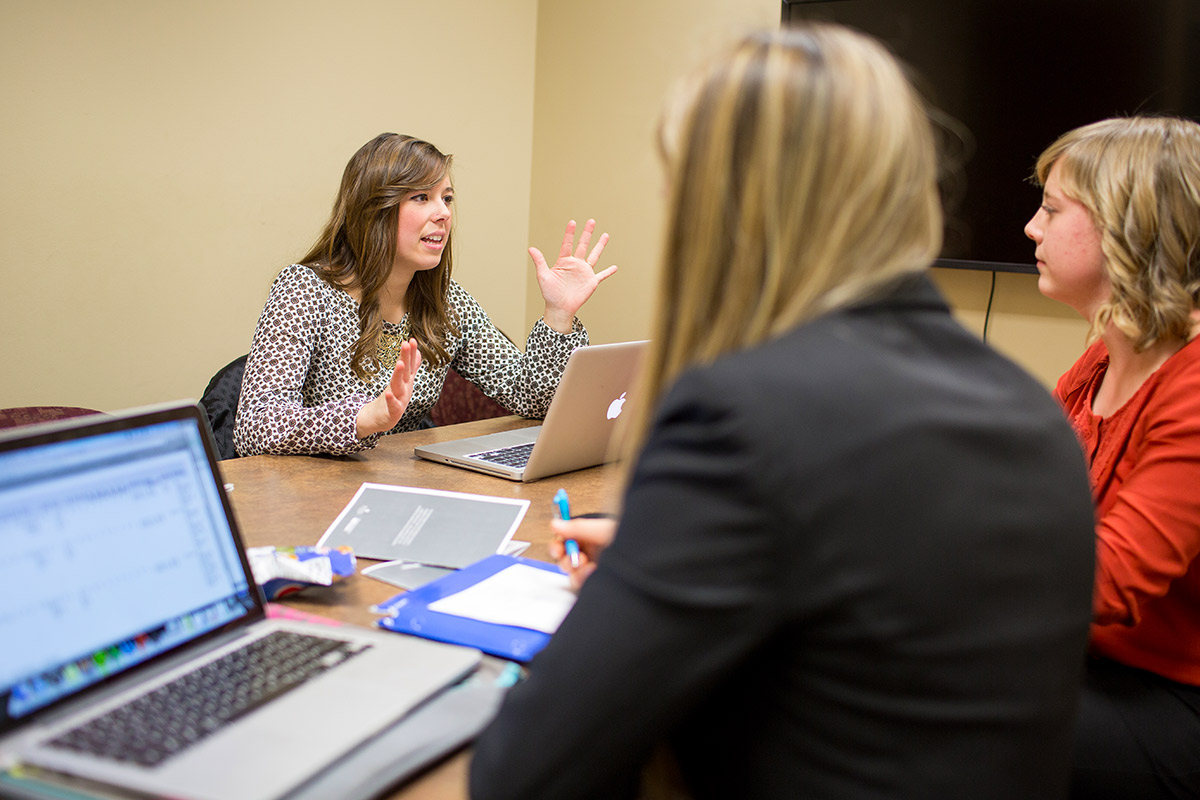 A business team sitting and conversing in a meeting.