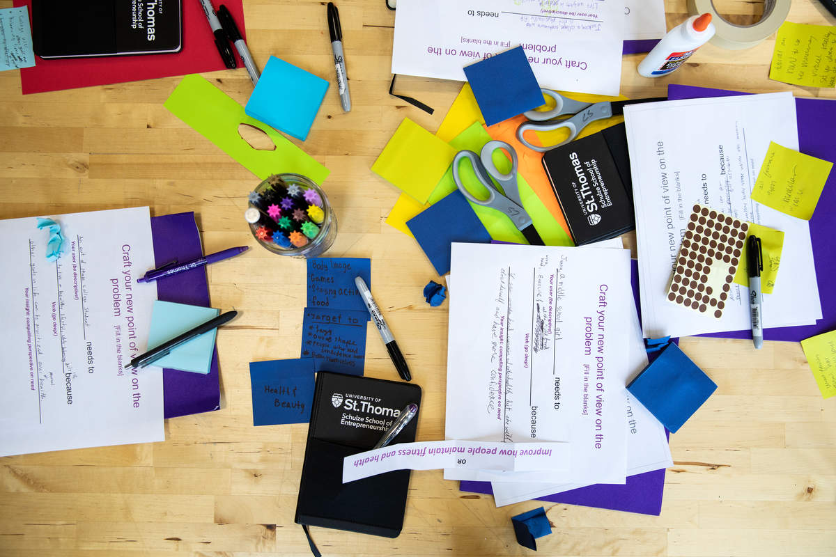 a cluttered desk with pencils, paper, and markers