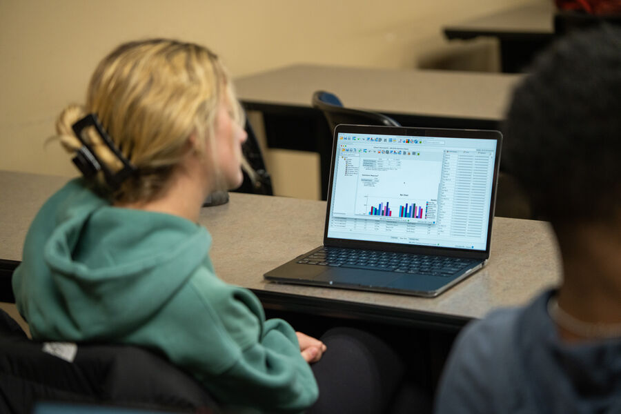 Opus Student looking at graph on laptop