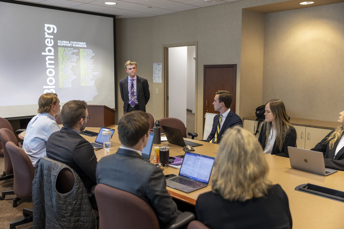 Finance students looking at market trends on screen