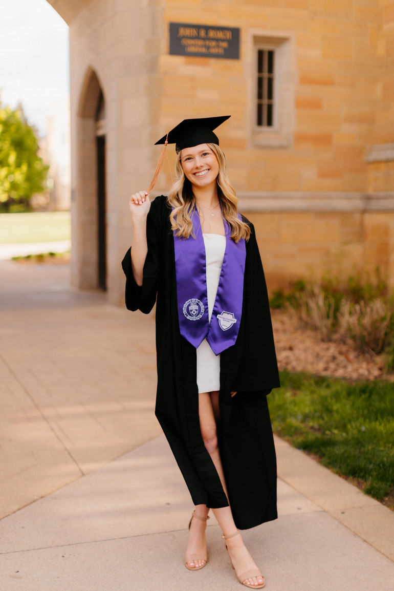 Justina Palmer ’24 poses for a photo in her cap and gown at the 2024 University of St. Thomas commencement ceremonies. 