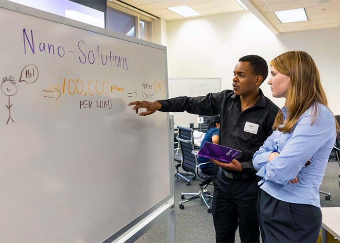 First-year business students brainstorm ideas together during an innovation session.