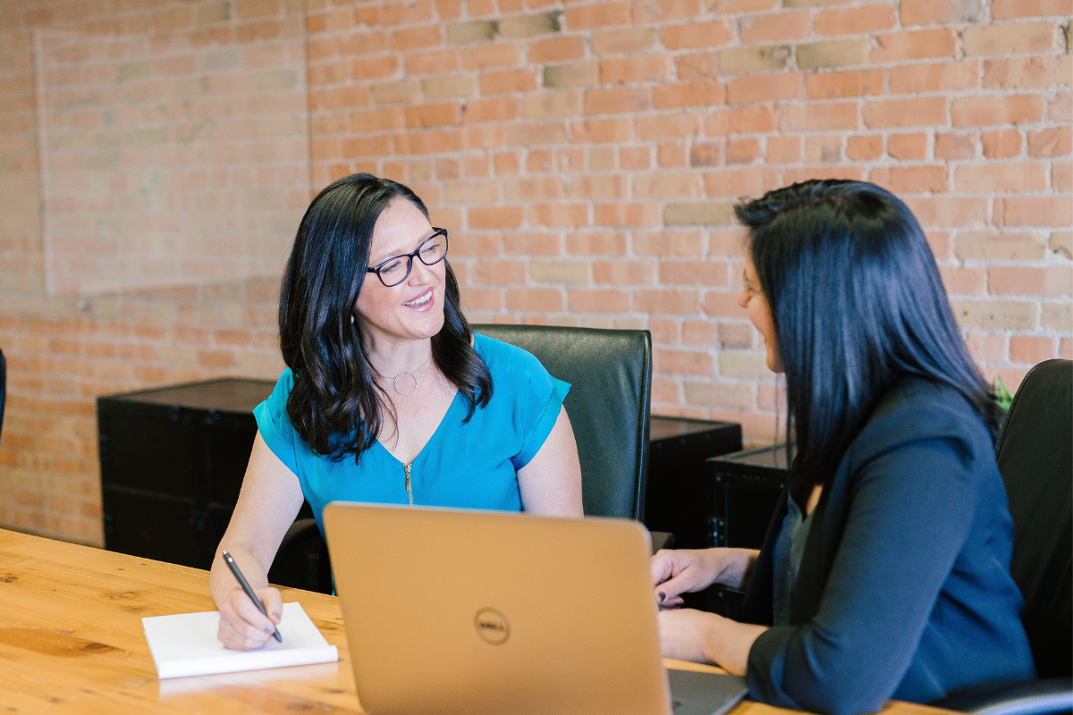 Two business women helping one another