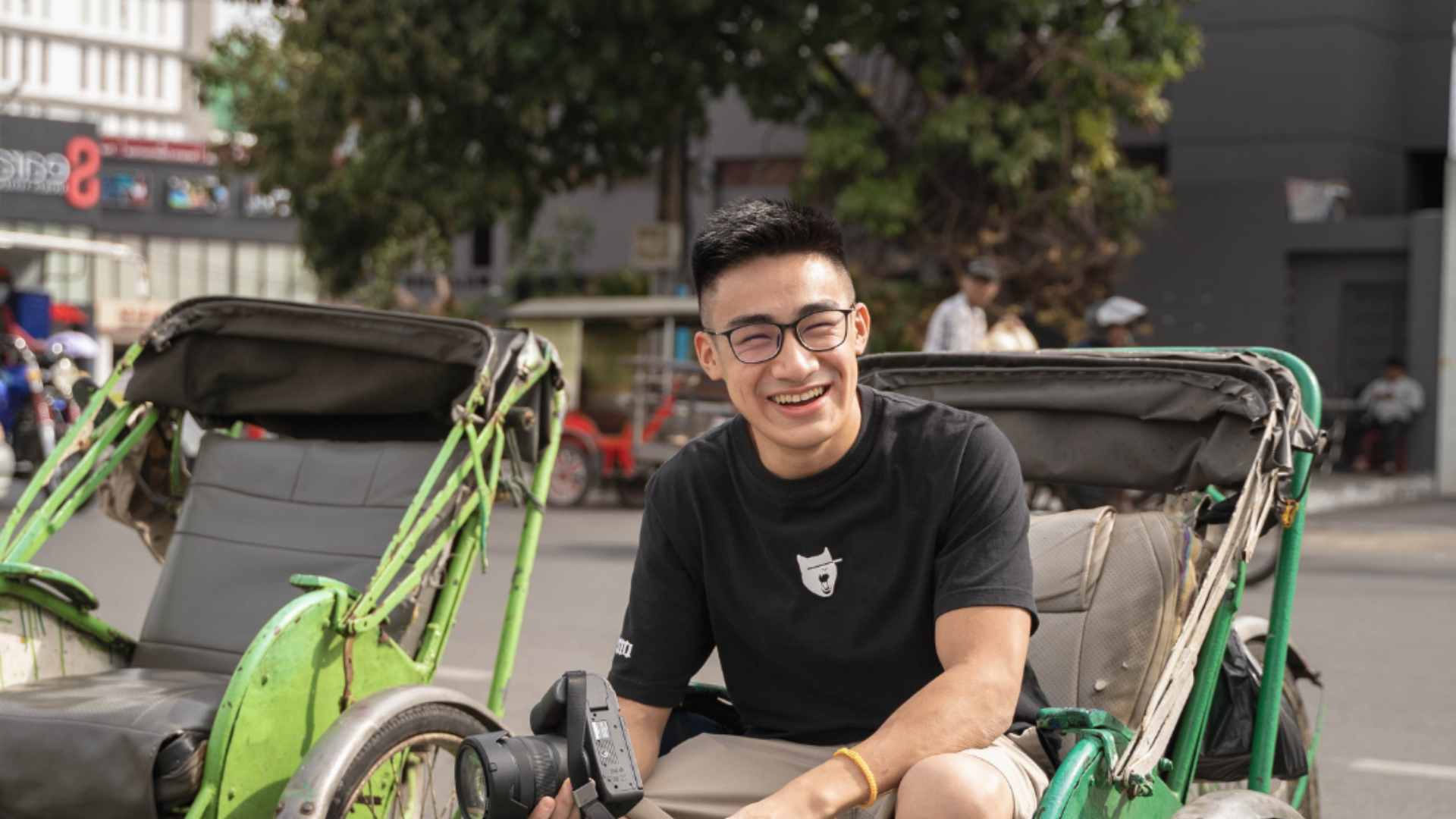 Social entrepreneur Hao Taing '23 posing in a cyclo taxi.