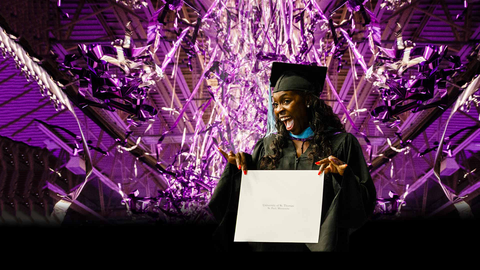 A student shows off her diploma at the commencement ceremony.