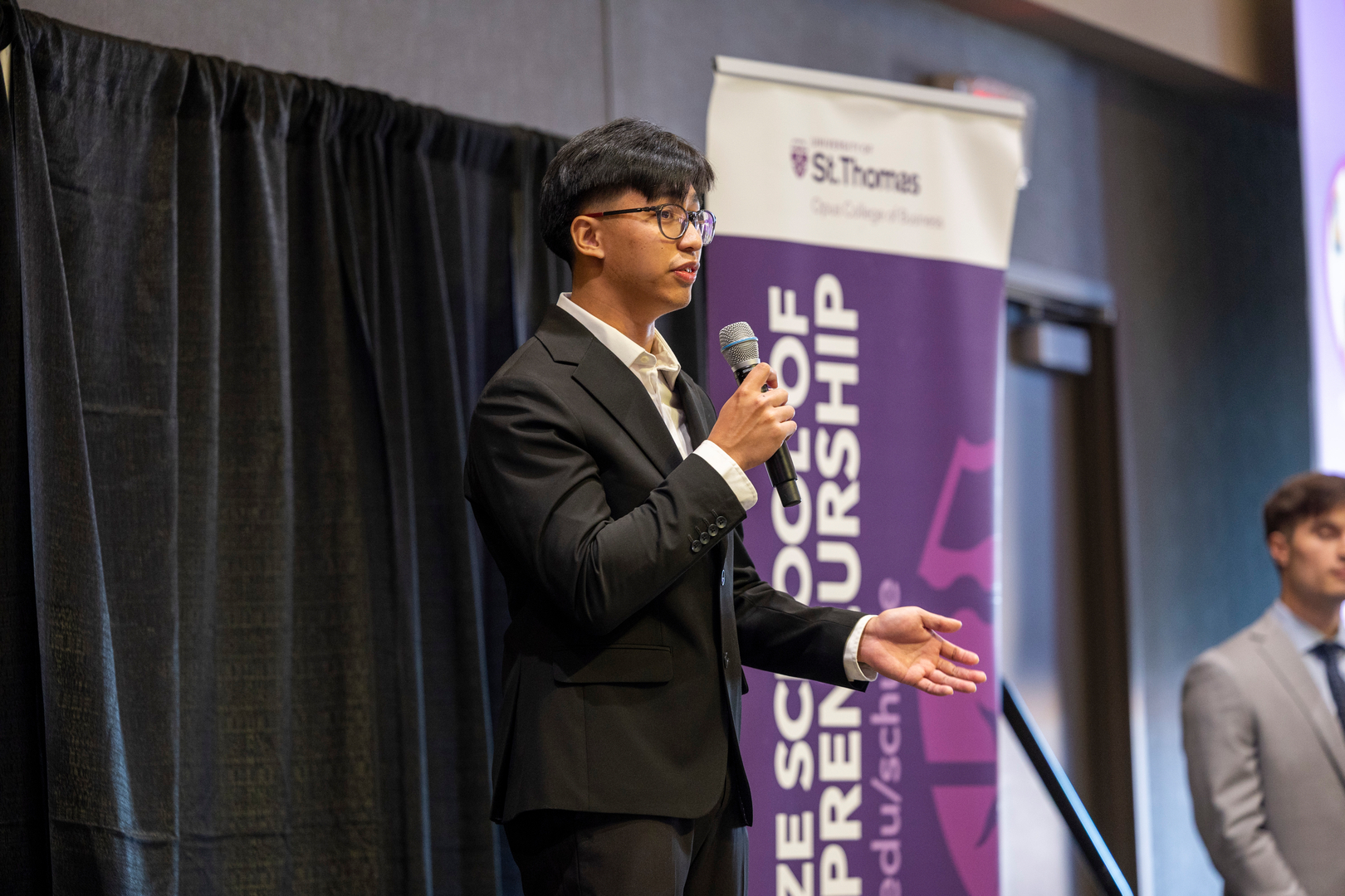 Student speaks on stage at the Fowler Business Concept Challenge event.